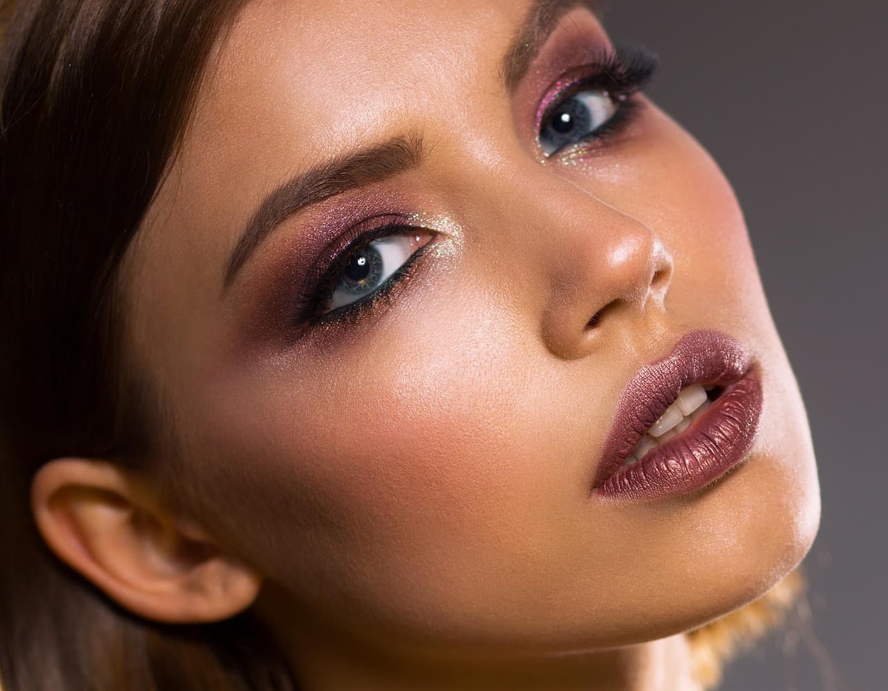 Close-up of a face with long, lifted lashes and full brows
