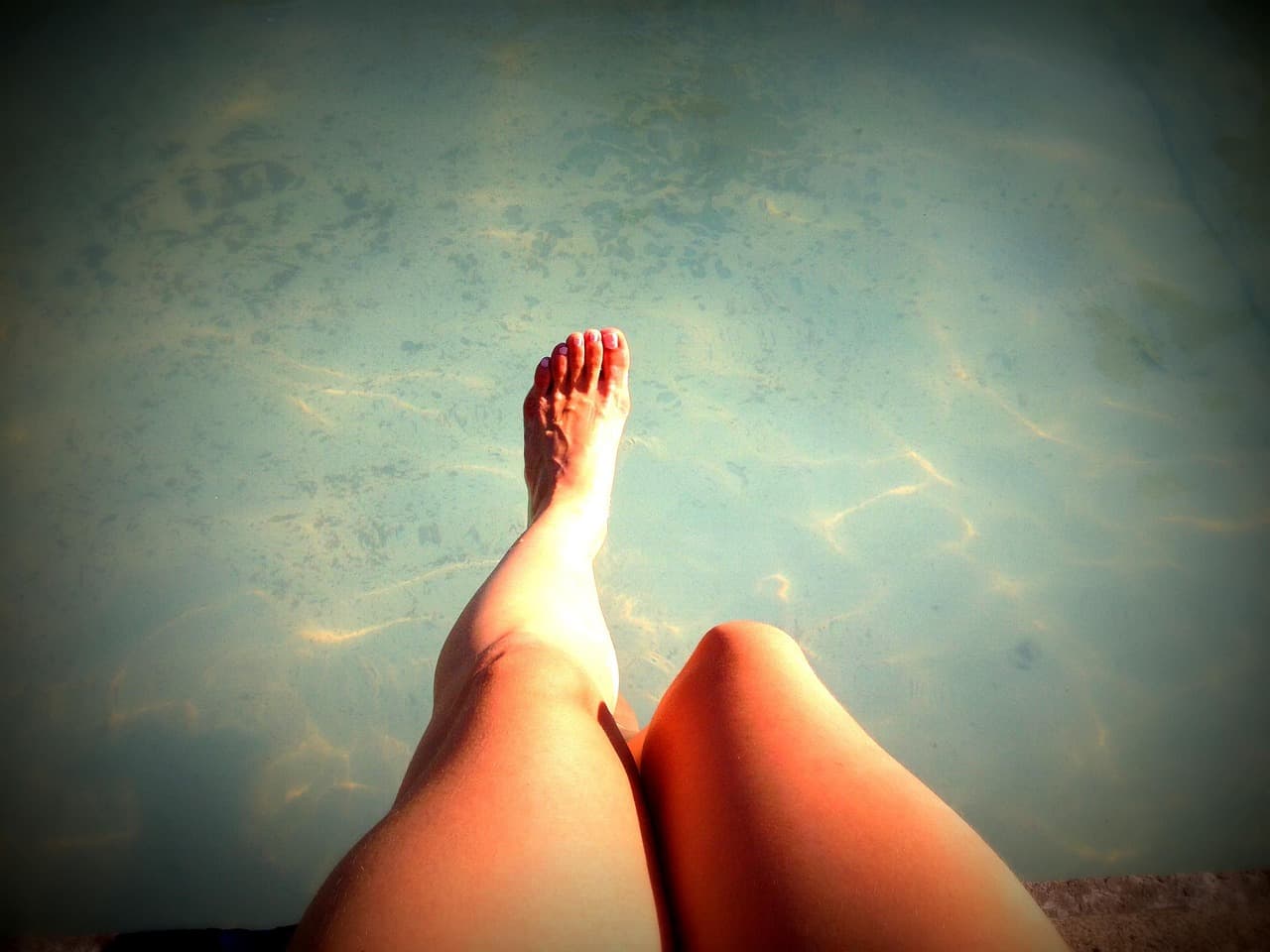 Smooth legs stretched out in clear blue water